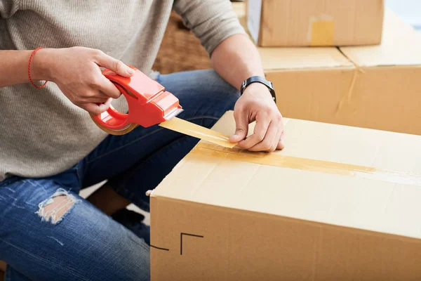 Kırpma adam yeni daireye taşınırken karton kutu mühür yapışkan bant kullanarak