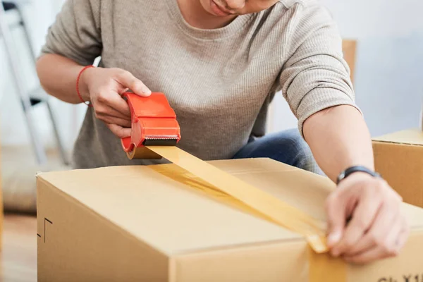 Onherkenbaar Jonge Man Met Plakband Verzegelen Kartonnen Doos Terwijl Verhuizen — Stockfoto