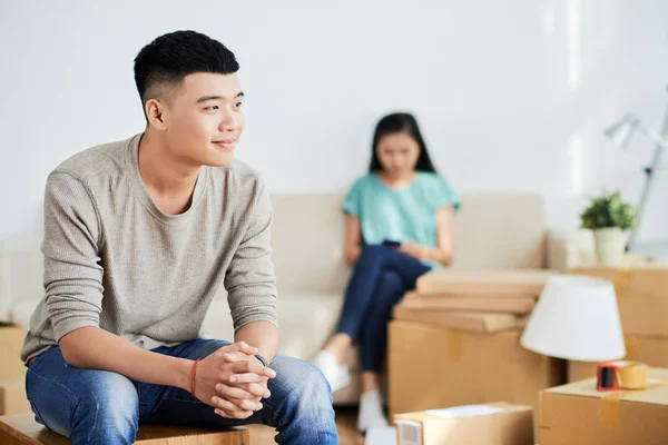 Ung Asiatisk Man Tittar Bort Medan Sitter Suddig Bakgrund Lägenhet — Stockfoto