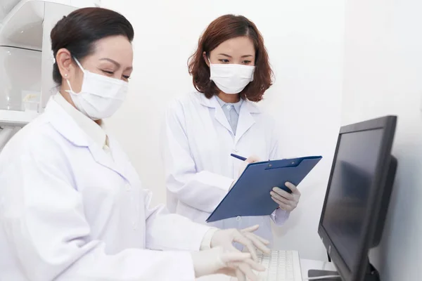 Dentista Lendo Prontuário Voz Alta Enfermeiro Inserindo Informações Computador — Fotografia de Stock