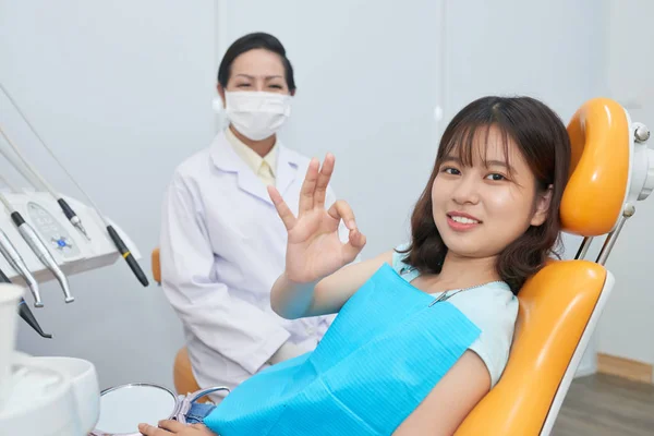 Ładna Nastoletnia Dziewczyna Siedzi Fotelu Dentysty Pokazując Znak Leczeniu Zębów — Zdjęcie stockowe