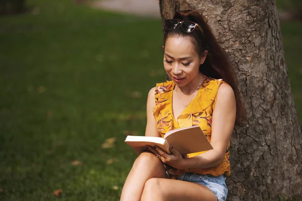 Studentka Siedząca Pod Drzewem Parku Czytając Powieść — Zdjęcie stockowe