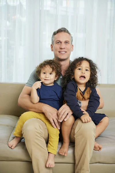 Gutaussehender Mann Mittleren Alters Auf Sofa Sitzend Mit Zwei Kindern — Stockfoto
