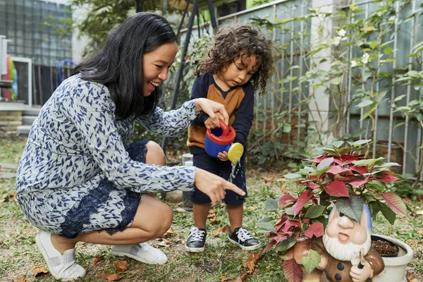 Glad Ung Mamma Visar Sin Son Till Vatten Blommor Trädgården — Stockfoto