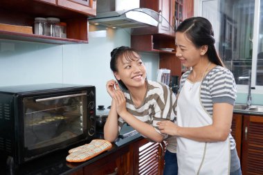 Neşeli Asyalı genç kız annesi ile yemek yapma keyfini