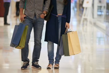 Alışveriş merkezinde duran birçok kağıt torbaile çiftin kırpılmış görüntüsü