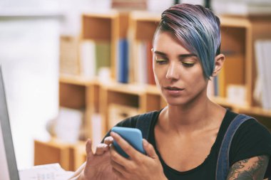 Renkli saçları akıllı telefonunda mesajları kontrol ile güzel genç kadın