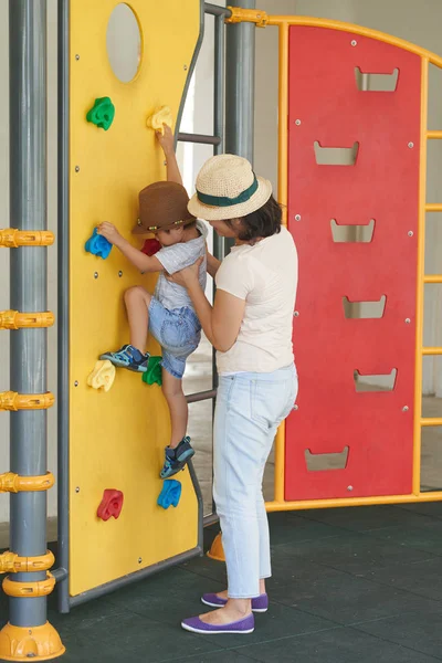 Moeder Helpt Haar Kind Klimmen Muur Speelplaats — Stockfoto