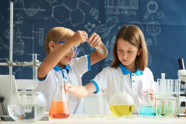 Okul laboratuvarında bilimsel deney üzerinde çalışan çocuklar
