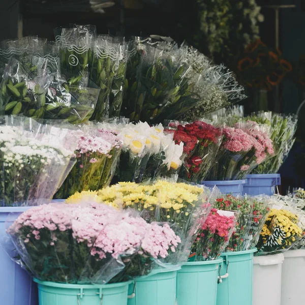市場の屋台で美しい異なる花を持つバケツ — ストック写真