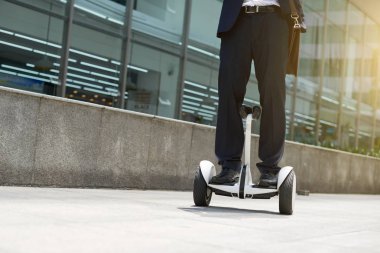 Şehir caddesi boyunca hoverboard sürme iş yöneticisi Bacaklar
