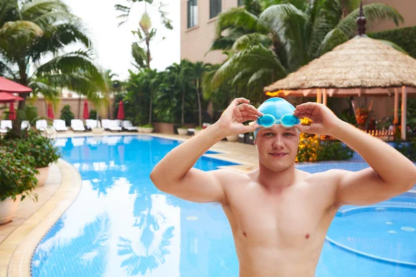 Sonriente Joven Guapo Poniéndose Gafas Para Nadar Piscina —  Fotos de Stock
