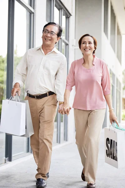 週末に買い物をする時に手をつないで幸せな老夫婦 — ストック写真