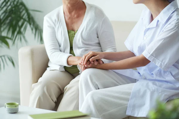 彼女を支えるために女性患者の手に触れる介護福祉士 — ストック写真