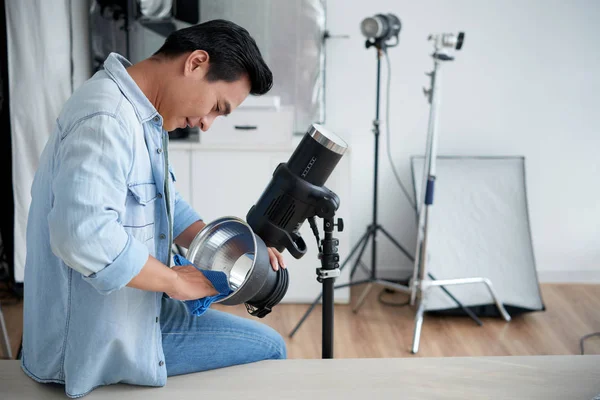 Young Vietnamese Photographer Cleaning Lightning Equipment Studio — 스톡 사진