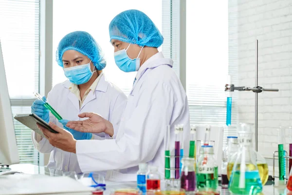 Equipe Cientistas Asiáticos Discutindo Líquido Verde Tubo Ensaio — Fotografia de Stock