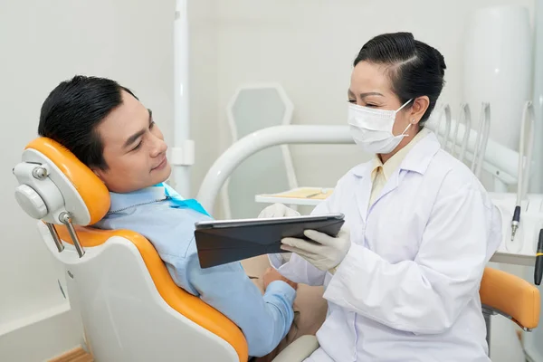 Starsza Kobieta Dentysta Pokazując Pacjenta Jego Szczęki Ray Komputerze Typu — Zdjęcie stockowe