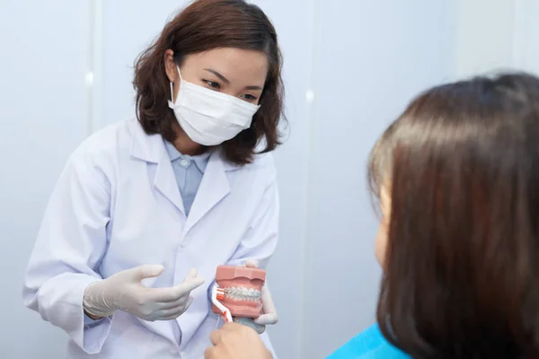 Lekarz Wyjaśniający Młody Pacjent Jak Szczotkować Zęby Szelkami — Zdjęcie stockowe