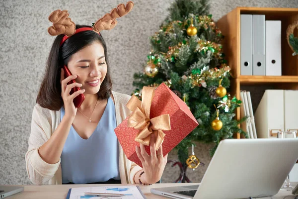 Ładne Uśmiechnięte Asian Business Lady Patrząc Giftbox Jej Ręce Dzwoniąc — Zdjęcie stockowe