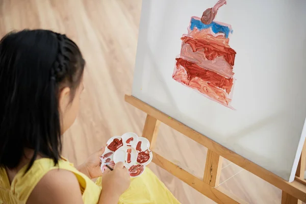 アートスタジオのキャンバスにケーキを描く小さな女の子 — ストック写真