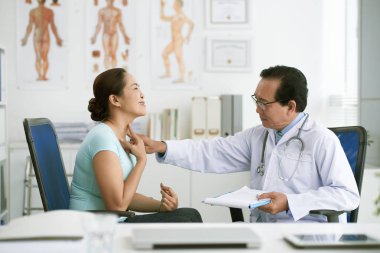 Doktor yaşlı kadının boğaz palpe tanı yapmak için