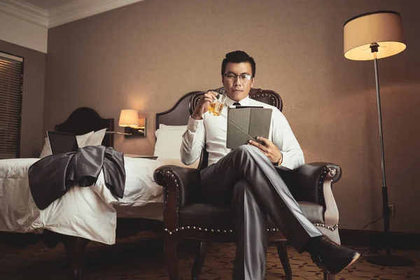 Successful Vietnamese Businessman Drinking Glass Whiskey Reading Information Tablet Computer — Stock Photo, Image