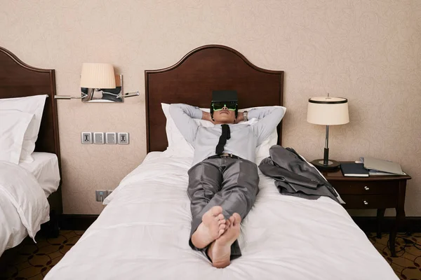 商人在酒店房间的床上放松 享受虚拟现实 — 图库照片