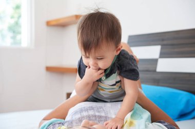 Küçük çocuk evde annesi ile oynarken parmaklarını emme