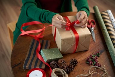 Noel hediyesi üzerinde yay bağlama kadın Eller 