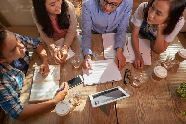 Grupa Studentów Picia Kawy Omawiania Prac Domowych Kawiarni Widok Góry — Zdjęcie stockowe