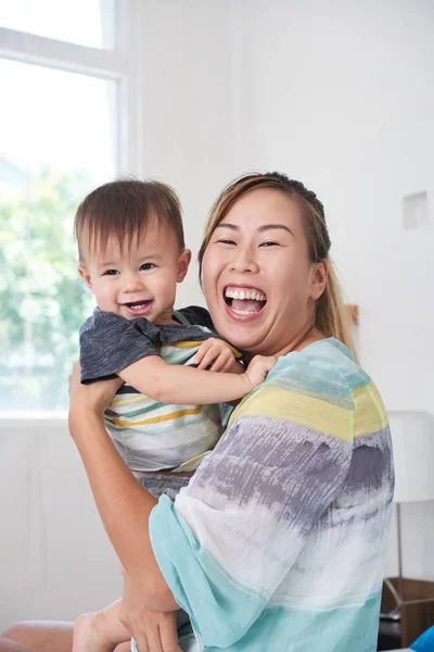 Rindo Feliz Jovem Mãe Carregando Seu Pequeno Filho Olhando Para — Fotografia de Stock