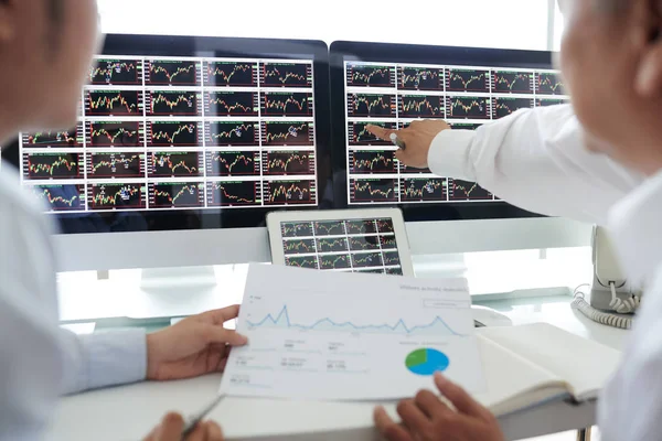 投资者在电脑屏幕上讨论股市数据 — 图库照片