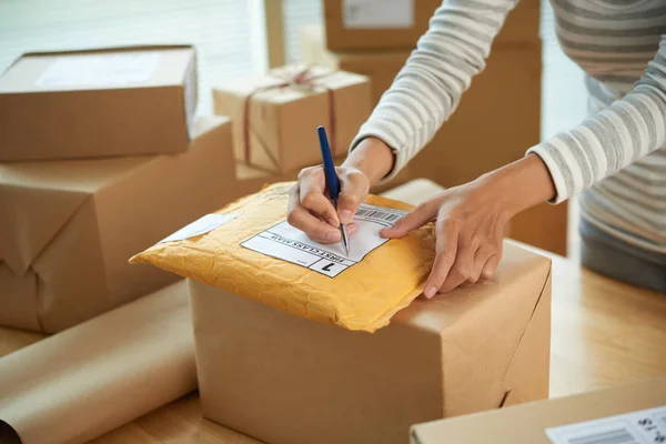 Händerna Kvinnan Skriver Adress Första Klassens Paket Med Varor — Stockfoto