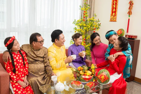 幸せなアジアの家族は お茶を飲み 背景に来年の最高の願いを持つカップルと旧正月のお祝いで新鮮な果物を食べます — ストック写真
