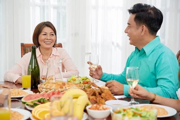 一群戴着酒杯的民族人在室内餐桌上一起吃着美味的晚餐 — 图库照片