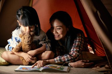 Gülümseyen Vietnamlı kadın küçük kızı okuma öğretim