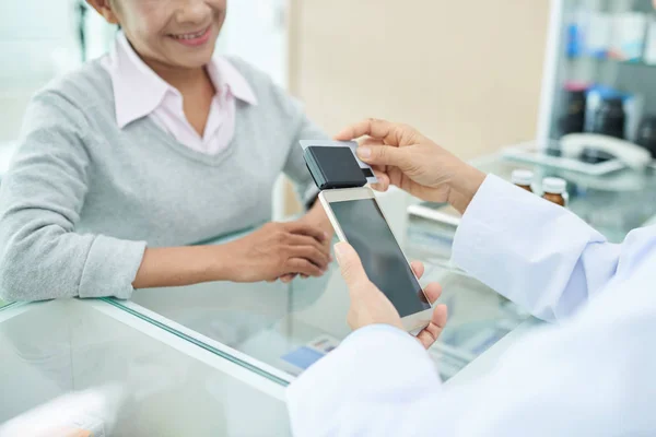 药剂师使用连接到智能手机的读卡器接受付款 — 图库照片