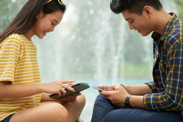 Sonriendo Joven Pareja Viendo Videos Gadgets Lugar Hablar — Foto de Stock