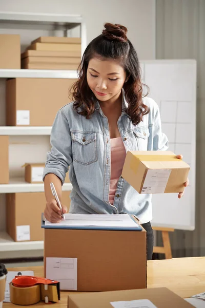 Unga Vietnamesiska Kvinnliga Lagerarbetare Med Paket Handen Skriver Ner Leveransuppgifter — Stockfoto