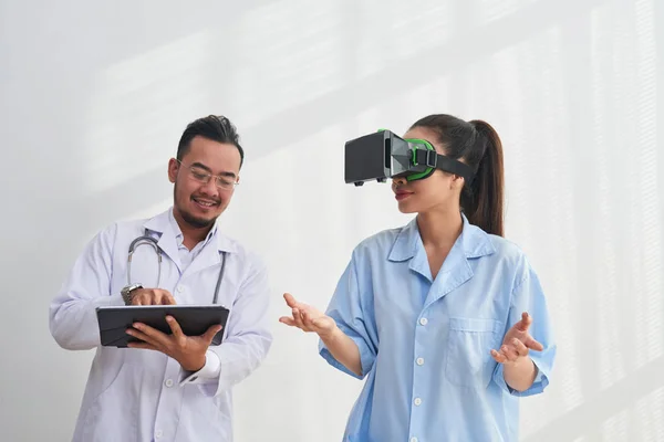 Sonriente Médico Asiático Controlando Aplicación Realidad Virtual Compañera Trabajo Está —  Fotos de Stock
