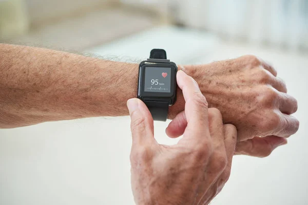 Starszy Człowiek Sprawdzanie Impuls Poprzez Aplikację Zdrowia Jego Inteligentny Zegarek — Zdjęcie stockowe