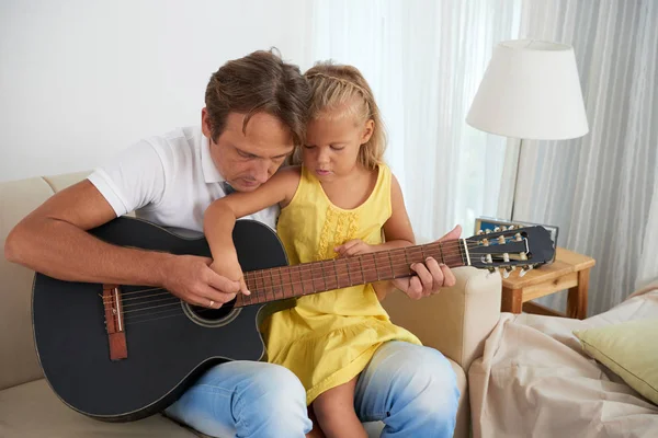 Young Man Showing His Daughter How Play Guitar — Stockfoto