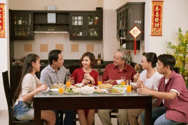Büyük Asyalı aile konuşma ve Ay Yeni Yıl kutlamaları, arka planda önümüzdeki yıl için en iyi dilek ile beyitler yemek yeme