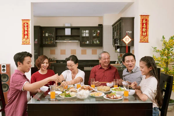 祖父母和孩子在农历新年庆祝活动中享用美食 在背景中与大家一起祝福来年 — 图库照片