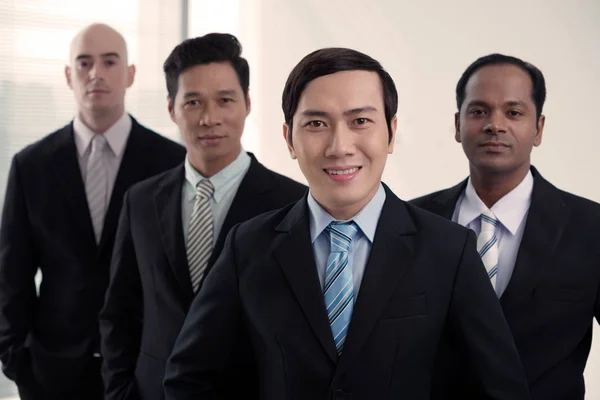 Joven Empresario Sonriente Frente Del Equipo Empresarial Internacional —  Fotos de Stock