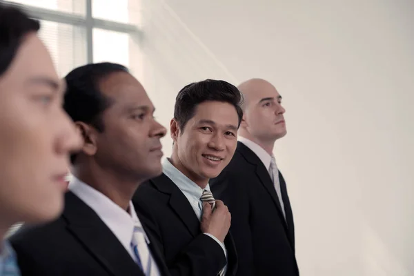 Handsome Smiling Vietnamese Man Adjusting Necktie Looking Camera Standing Coworkers — Stock Photo, Image
