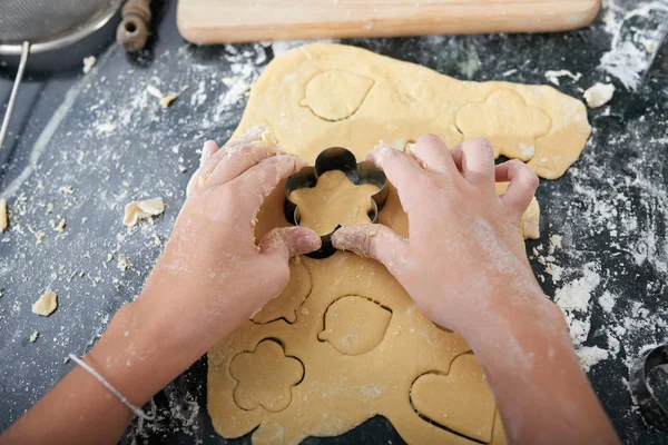 Handen Van Het Kind Snijden Verschillende Kerstkoekjes Uit Uitgerold Deeg — Stockfoto