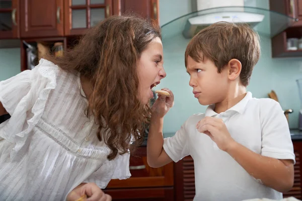 愤怒的男孩喂养共享饼干与姐姐 — 图库照片