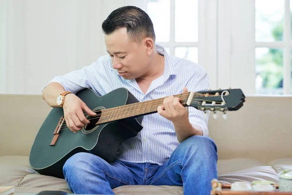 Junger Mann Spielt Gitarre Während Hause Auf Dem Sofa Sitzt — Stockfoto