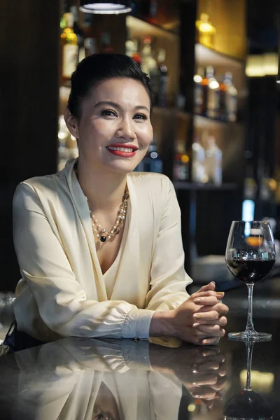 ワインにグラスを飲みながらレストランで休む中年の獣医の女性の肖像 — ストック写真